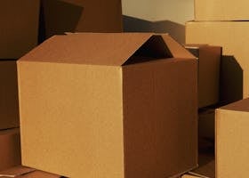 Stacked cardboard boxes ready for shipping or storage in a warehouse setting.